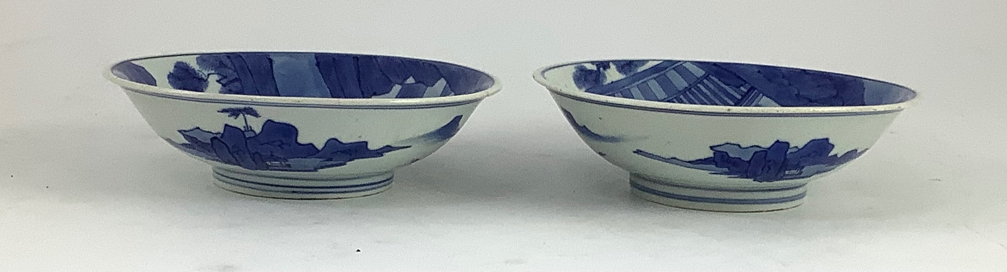 NB BOTH WITH HAIRLINE CRACKS A pair of Chinese blue and white small dishes, Kangxi six character marks and of the period (1662-1722), 15.7cm and 15.8cm diameter, foot later pierced, hairline cracks